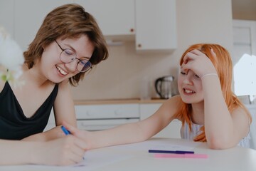 A 13-year-old teenage girl and her mother are drawing and playing together. They enjoy creative...