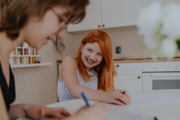 A 13-year-old teenage girl and her mother are drawing and playing together. They enjoy creative...