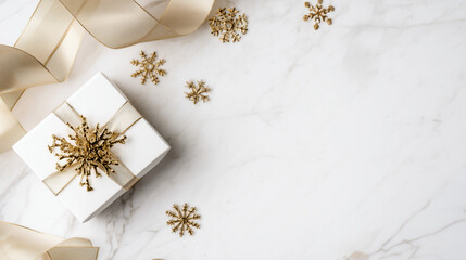 white present box with gold ribbon surrounded by subtle snowflake elements on white marble background