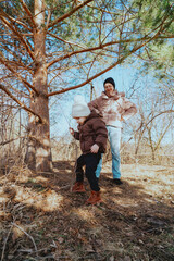 A mother and her 3-year-old daughter walk together in the park, enjoying nature and quality family time. A heartwarming moment of love, care, and happiness as they explore the outdoors together