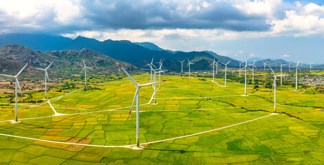 Panoramic view of wind farm or wind park. Wind turbines generating electricity on rice field at Phan Rang, Ninh Thuan, Vietnam. Clean energy concept