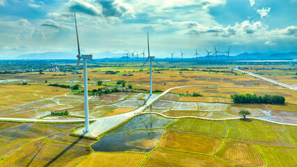 Panoramic view of wind farm or wind park. Wind turbines generating electricity on rice field at Phan Rang, Ninh Thuan, Vietnam. Clean energy concept