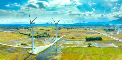 Panoramic view of wind farm or wind park. Wind turbines generating electricity on rice field at Phan Rang, Ninh Thuan, Vietnam. Clean energy concept