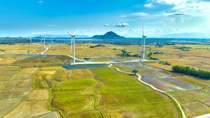 Panoramic view of wind farm or wind park. Wind turbines generating electricity on rice field at Phan Rang, Ninh Thuan, Vietnam. Clean energy concept