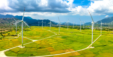 Panoramic view of wind farm or wind park. Wind turbines generating electricity on rice field at Phan Rang, Ninh Thuan, Vietnam. Clean energy concept