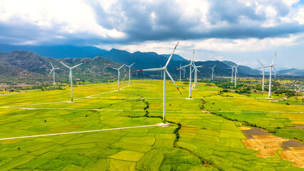 Panoramic view of wind farm or wind park. Wind turbines generating electricity on rice field at Phan Rang, Ninh Thuan, Vietnam. Clean energy concept