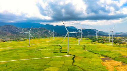 Panoramic view of wind farm or wind park. Wind turbines generating electricity on rice field at Phan Rang, Ninh Thuan, Vietnam. Clean energy concept