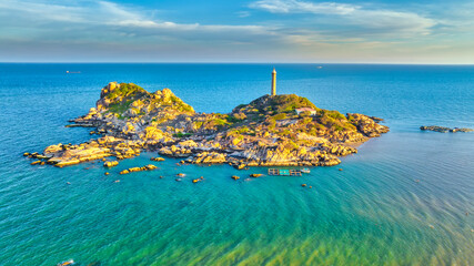 Landscape of small island with ancient lighthouse at sunrise sky is beautiful and peaceful. This is only ancient lighthouse is located on island in Vietnam