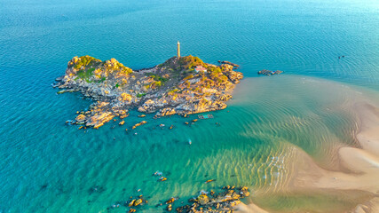 Landscape of small island with ancient lighthouse at sunrise sky is beautiful and peaceful. This is only ancient lighthouse is located on island in Vietnam