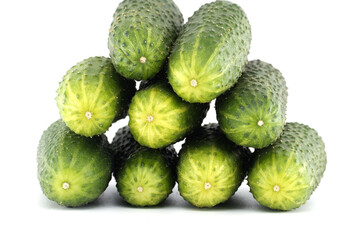 Delicious arrangement of fresh, green cucumbers stacked on a white surface, ready to eat.