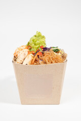 Delicious Asian noodles with fresh ingredients in an eco-friendly takeaway box. isolated on white background