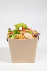 Delicious Asian noodles with fresh ingredients in an eco-friendly takeaway box. isolated on white background