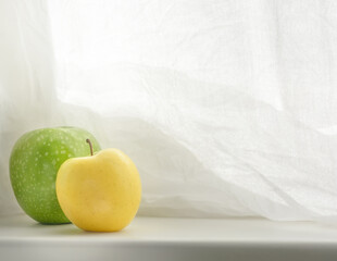 Light background with yellow apple, selective focus