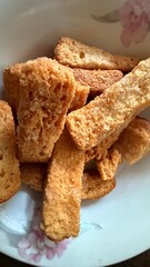 Crispy sugar coated toast pieces are piled inside a white floral patterned bowl