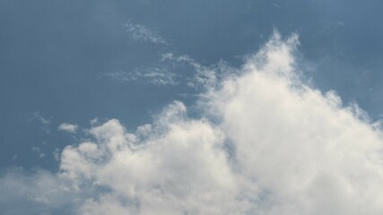 Soft, white clouds drift slowly across a tranquil blue sky creating a peaceful vista