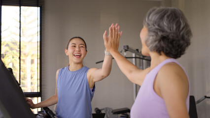 Young active adult child and mature middle age old mum run walk advice workout at gym. Love mental health care older retired mom asia elder people happy protect aging life balance enjoy sport club.