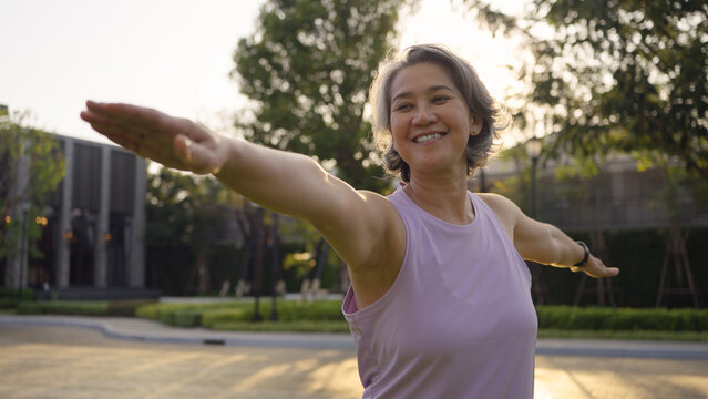 Asia adult aged people middle age mindful happy old woman yoga body pose zen calm stress relief outdoor nature public park sun light self love relax elder aging life asian female mental health care.
