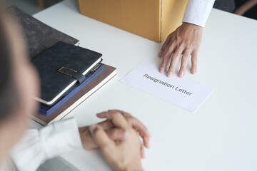 Business man sending resignation letter to boss and Holding Stuff Resign Depress or carrying cardboard box by desk in office