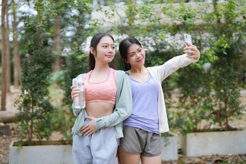 Fototapeta premium cheerful woman&nbsp;friends Sporty fitness girl takes selfie in park.