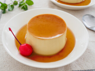 白い皿の上のサクランボを添えた手作りプリン