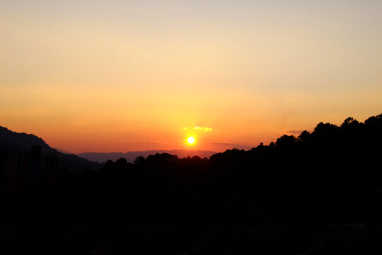 Dramatic sky with sunset shining over the silhouette mountain