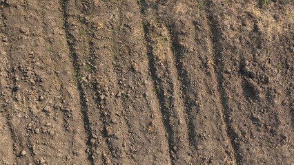 The drone captures the earth’s surface in transition, with deep furrows and soft clods of soil ready to be seeded, embodying the cycle of life and growth on the farm.
