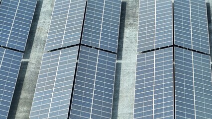 Obraz premium An aerial perspective shows the scale of a solar farm, where vast panels are strategically placed to maximize sunlight capture, marking a significant step toward renewable energy dominance. 