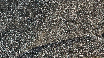 The aerial shot shows the vast spread of glass waste, illustrating the beginning of the recycling...