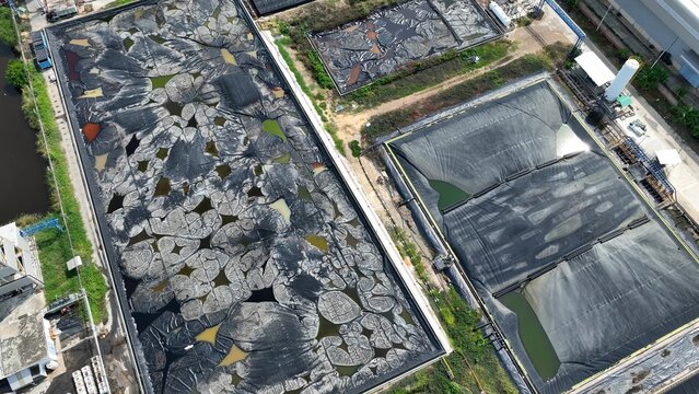 The site displays mixed containment conditions, active sludge ponds with compromised linings and a newer section ready for use or recently drained.
