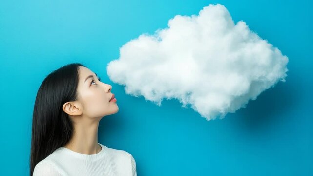 Young woman gazing at a fluffy cloud against a blue backdrop