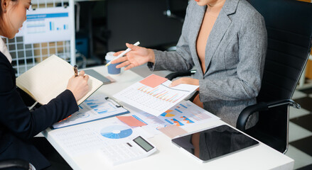 The business team analyzes revenue charts and graphs with laptop and tablet.Business analysis