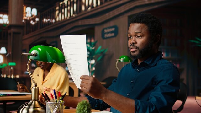 Black student rehearsing lines from the script for drama school course, auditioning for a theatre play competition. Young scholar reciting dialogue at the campus library. Camera A. - Powered by Adobe