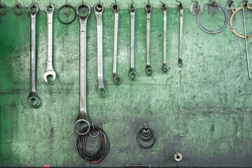 Wrenches and tools organized on wall in workshop.