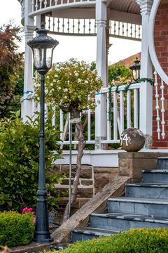 Bushes in garden with front steps up to veranda of home