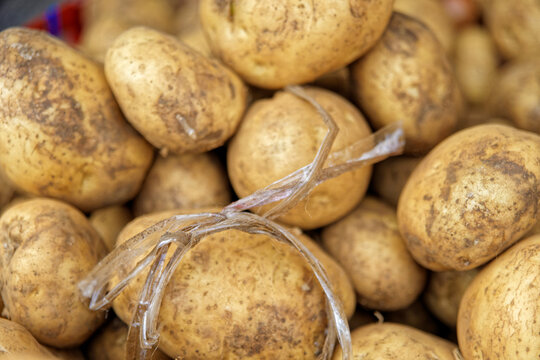 Close-up of unwashed brown potatoes for sale at fresh produce stall at market