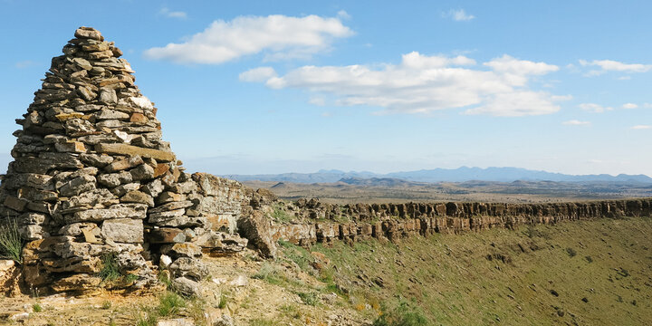 Large rock cairn with stunning rocky landscape in background