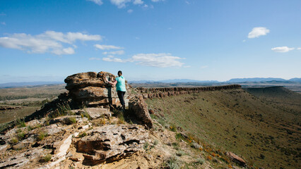 A woman in hiking gear overlooking the rugged landscape of the Flinders Ranges