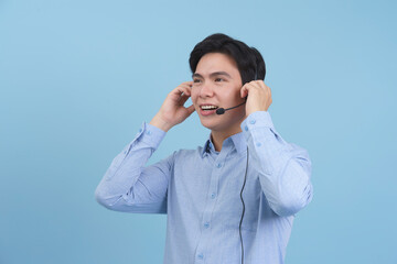 Smiling young man with headset engages in conversation against a blue background