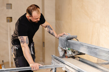 Construction worker cutting ceramic tile using electric saw