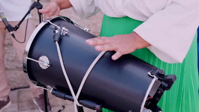 close up of hands playing repinique drum during live samba performance at outdoor event
