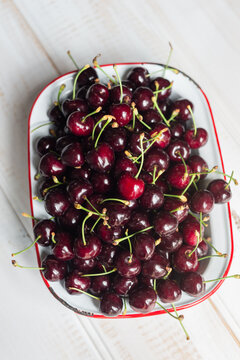 Fresh juicy cherries in an old enamelware dish