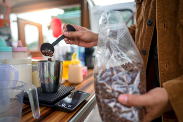 Male barista serving coffee at a table. A small business of a coffee shop or cafe on a truck