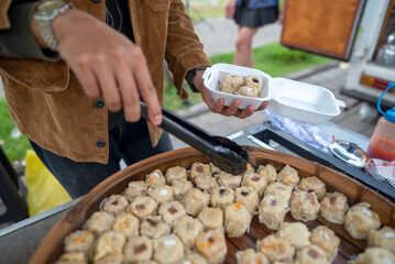 Male waiter is preparing food for serving to customers. A small business on a truck
