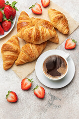 Delicious french breakfast with croissants, coffee and strawberries