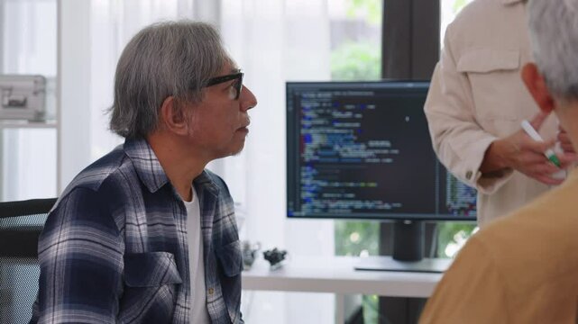 senior programmer bootcamlp,Asian young instructor guides senior learners through a programming on whiteboard, highlighting algorithm thinking and simple code exercises