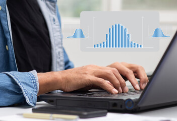 Businessman work with laptop and analyzing distribution data with histogram graph statistical process control and development process at workplace, quality control improvement concept