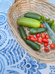 Freshly picked summer vegetables in a basket on blue pattern