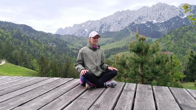 Practicing mindfulness meditation surrounded by Alps mountains