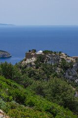 Monolithos Castle on top of a mountain with a white chapel and a view of the Aegean Sea vertical orientation (Rhodes, Greece)