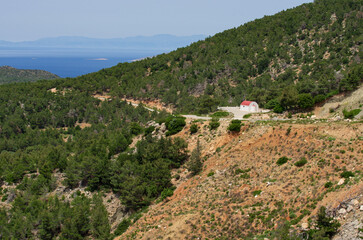 Beautiful mountainous landscape with a white Orthodox chapel and views of the Aegean Sea (Rhodes, Greece)